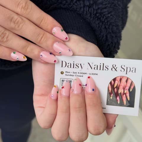 Client with dotted French tips holding a business card
